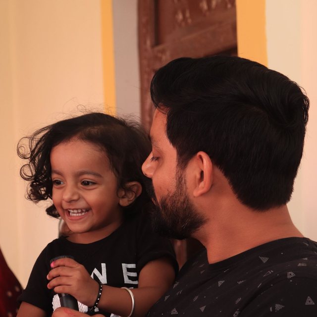 A proud father holding his laughing son