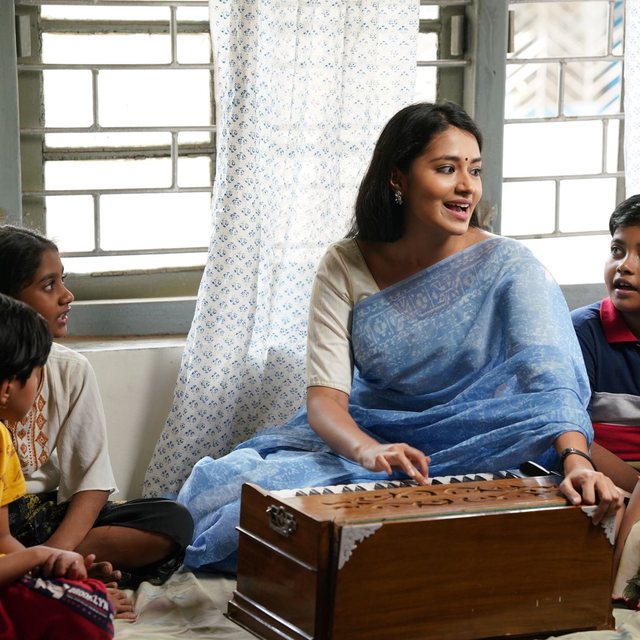 A teacher sitting with a group of children, guiding their lesson